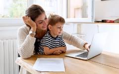 妈妈抱着孩子在笔记本电脑上打字.