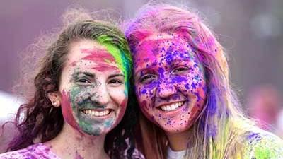 两名女学生脸上涂满了节日集会上的彩色粉末.